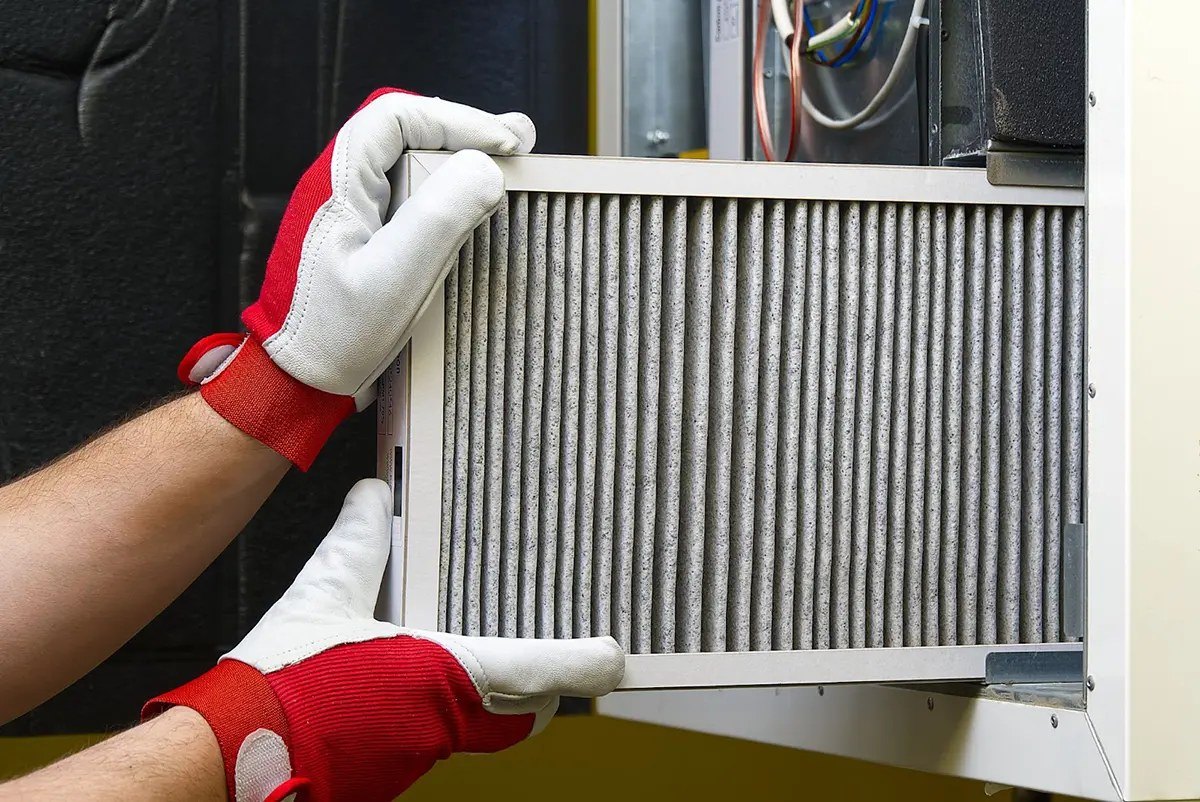 New furnace filter being fitted during a tune-up